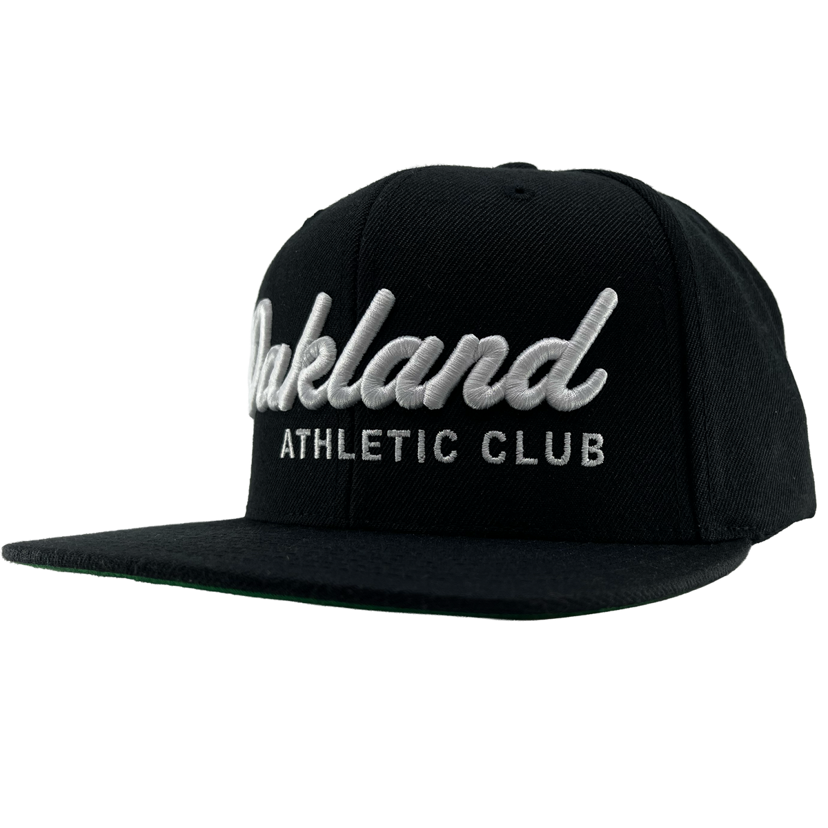 The OAC Script Snapback by OAC is a black snapback cap featuring white embroidered “Oakland” in cursive with “ATHLETIC CLUB” in bold capital letters beneath it. This adjustable hat is displayed at a slight angle on a plain white background, highlighting the classic style of the Oakland Athletic Club.