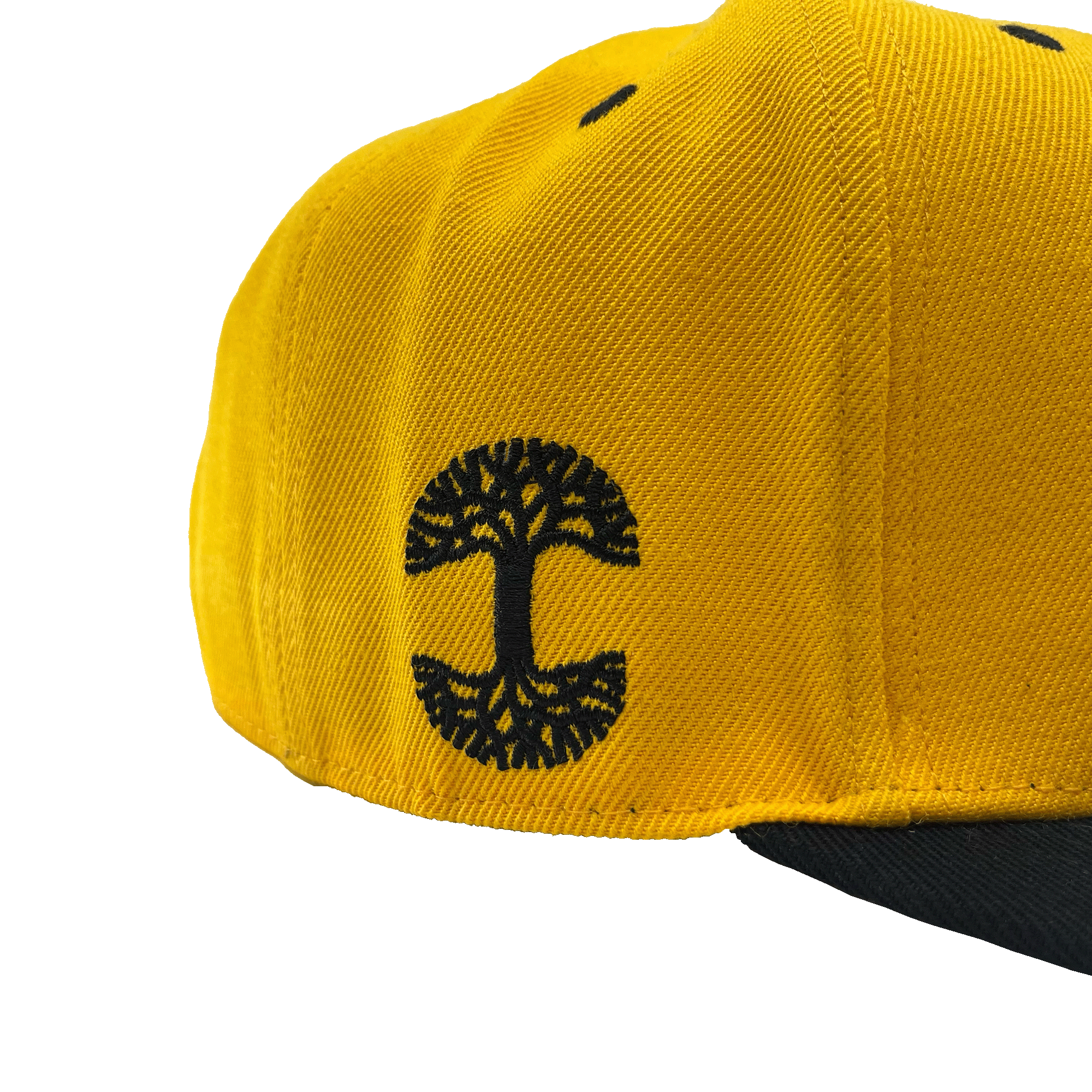 Side view of a yellow hat and black embroidered Oaklandish tree logo on the wearer's right side.