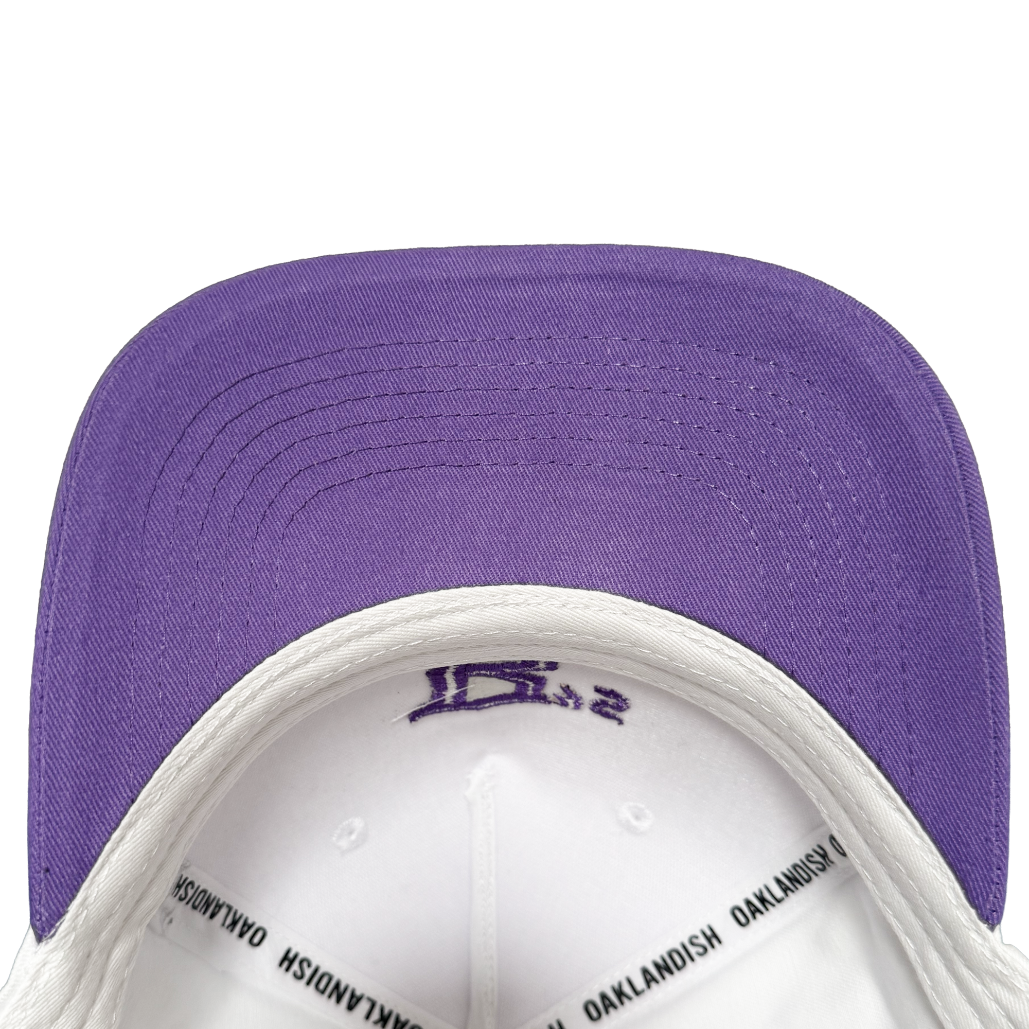 Showcasing the Oakland Ballers 5 Panel Cap, this stylish snapback features a crisp white crown with a solid purple brim—perfect for any Oakland Ballers supporter. The inside band is detailed with “OAKLANDISH” in bold black text, while purple stitching accents both the top and underside of the brim, capturing the vibrant spirit of the Oakland Ballers baseball team.