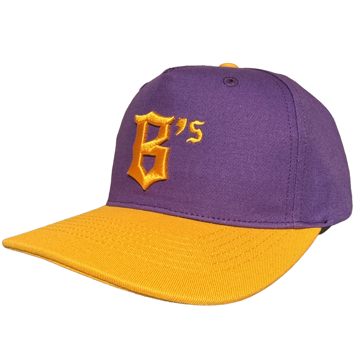 Here’s a rewritten version using your product data: A purple Oakland Ballers 5 Panel Cap featuring a yellow brim and top button. The front displays a yellow embroidered “B’s” in stylized text, representing the Oakland Ballers baseball team. The background is plain white.