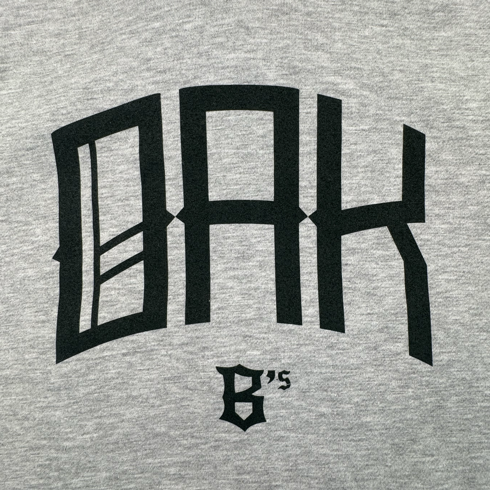 The OAK Ballers Hoodie by Oakland Ballers features gray fabric with large, bold black "OAK" text and "6’s" in smaller, sharp-angled gothic font—a tribute to the Oakland Ballers Pioneer League baseball team.
