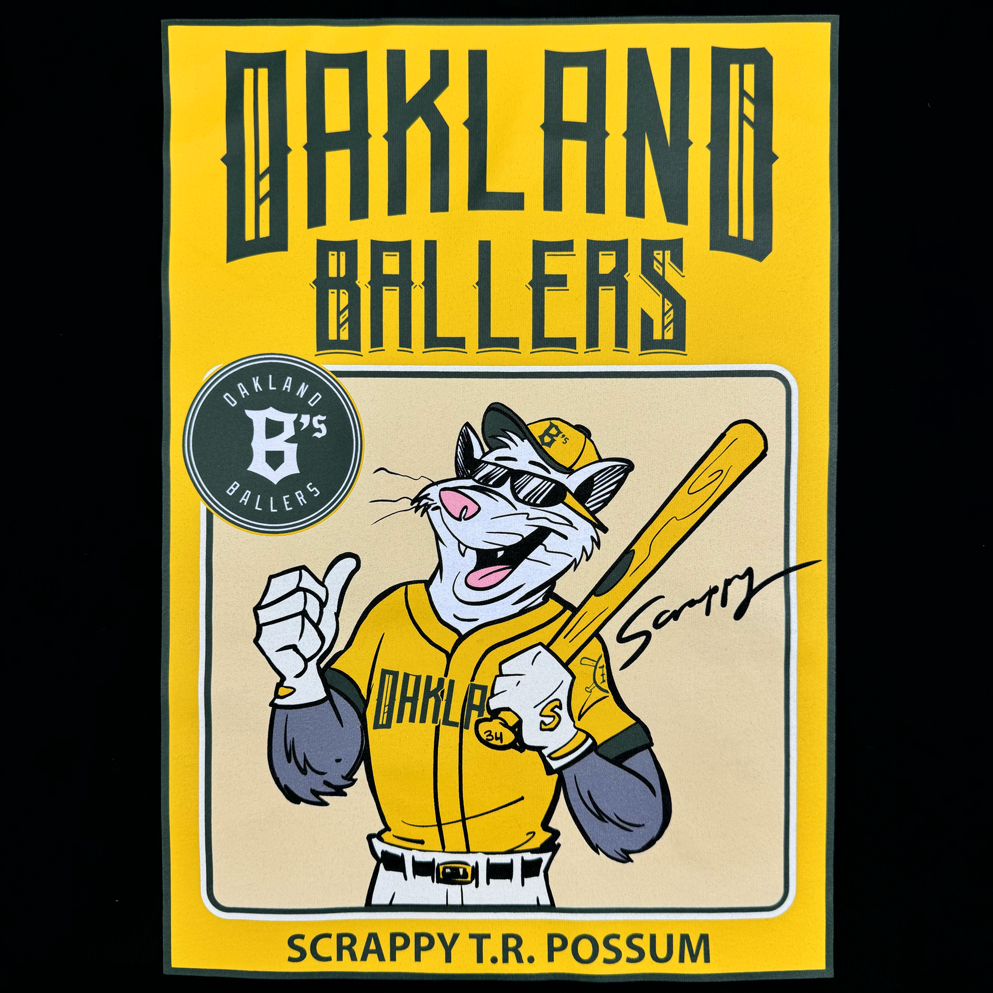 The Toddler Scrappy Rookie Tee by Oakland Ballers features a cartoon possum in a yellow team uniform and cap with bat and thumbs up, set on a yellow background with "OAKLAND BALLERS," the logo, and “Scrappy the Rally Possum.”.