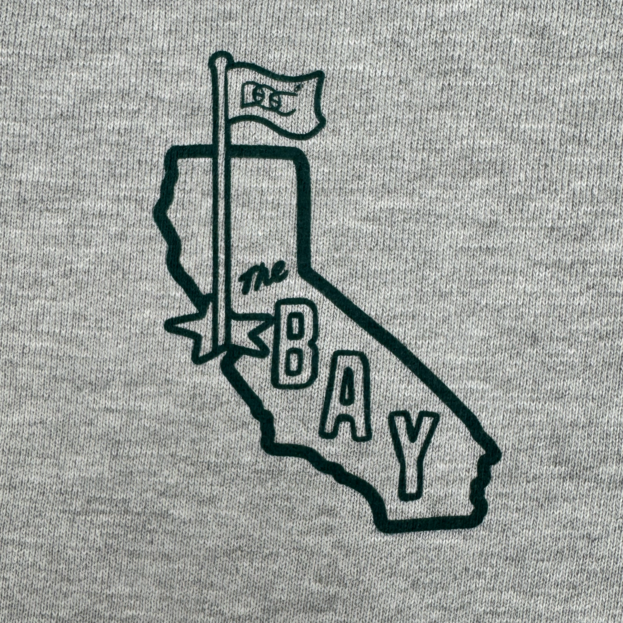 The Bay Area CC Hoodie By DOC from Oaklandish features a black outline of California with a "1850" flag and "THE BAY" text on gray heavyweight fleece in men's sizing, celebrating the San Francisco Bay Area in a simple graphic style.