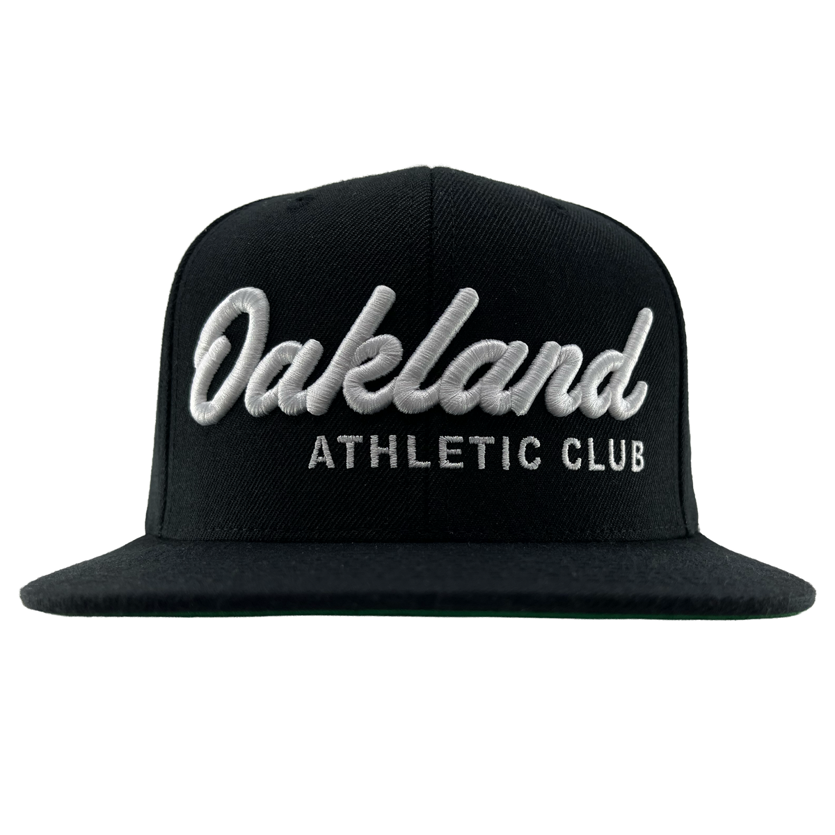 The OAC Script Snapback by OAC is a black flat-brimmed, adjustable cap featuring bold white cursive “Oakland” lettering above smaller block “ATHLETIC CLUB” text on the front, standing out against a plain white background.