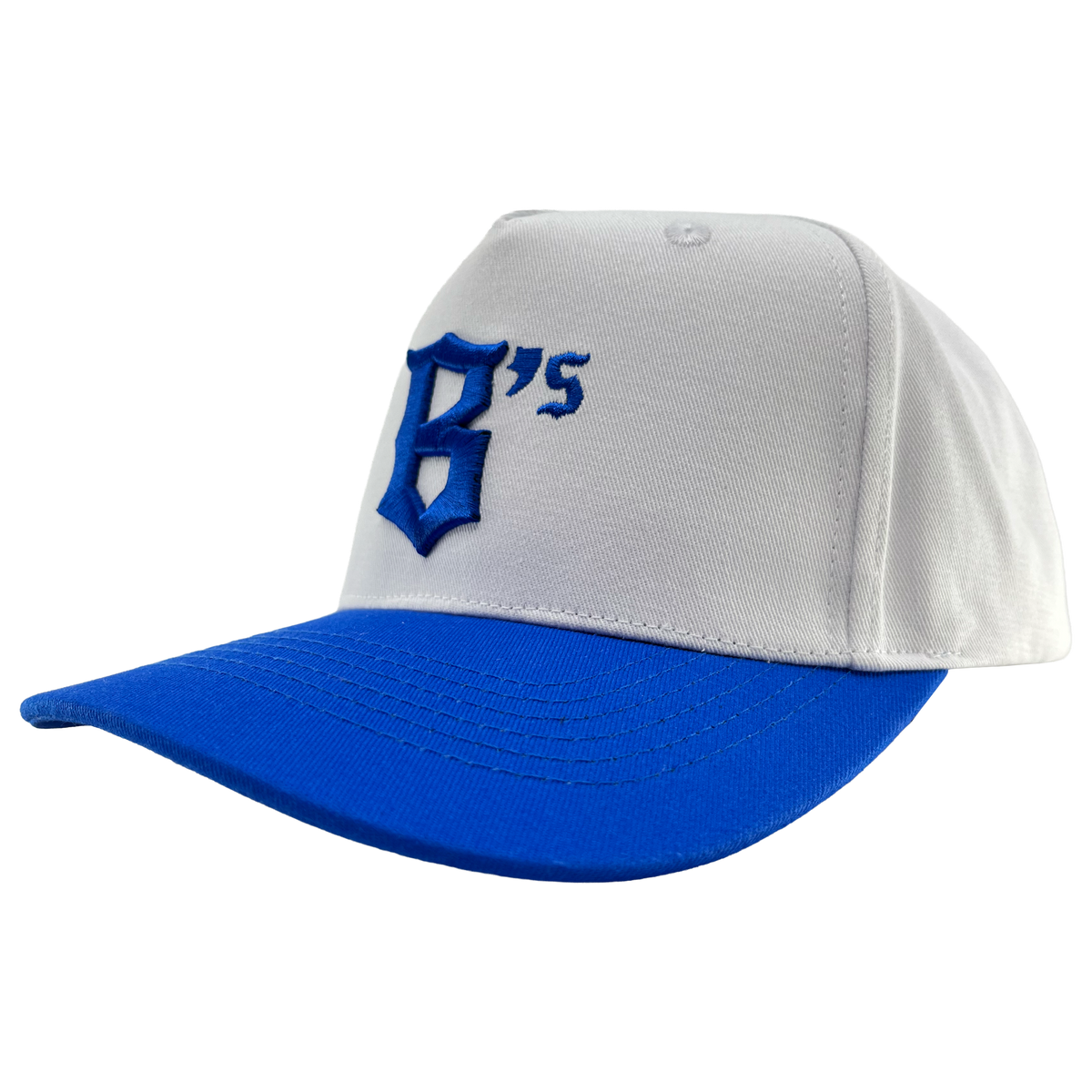 The Oakland Ballers 5 Panel Cap is a white snapback hat with a royal blue brim. The front showcases a bold, stylized blue “B” alongside a small blue “‘s,” representing the Oakland Ballers. The background of the cap is plain white.