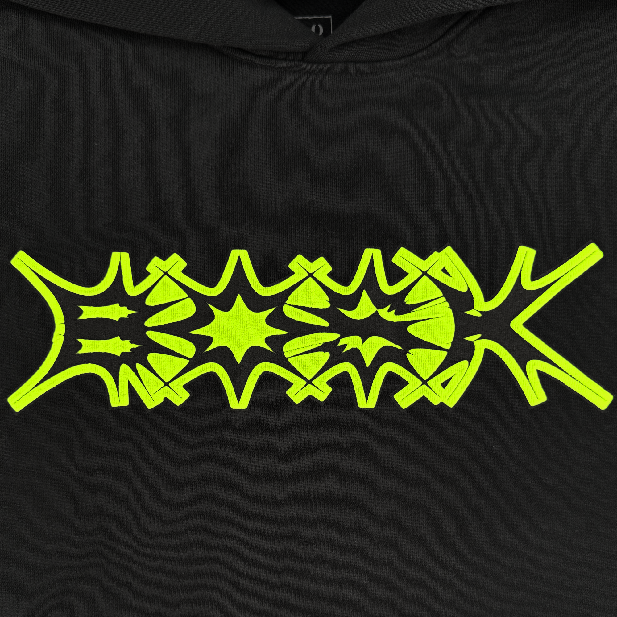 The BOSK Distortion Hoodie is a black cotton fleece with an oversized drop shoulder design, featuring bright yellow abstract typography in distorted starburst shapes that add energetic contrast to the pigment-dyed dark fabric with bold and dynamic jagged edges.