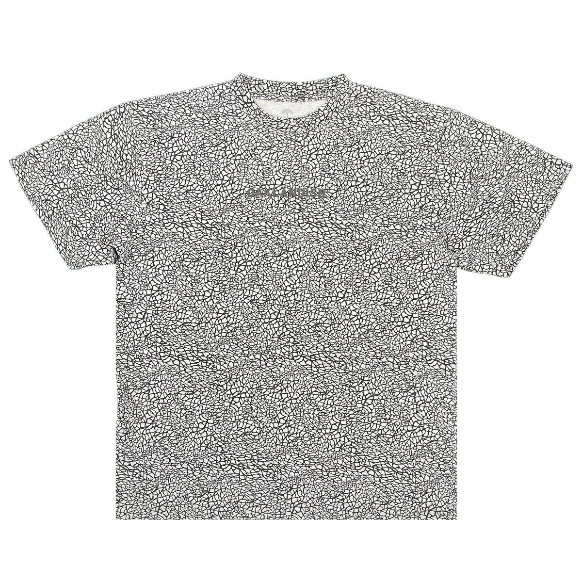 Short-sleeved Oaklandish Classic Logo Tee in a classic fit, crafted from heavyweight cotton and featuring an all-over black-and-white cracked elephant print pattern. The shirt is laid flat on a white background and showcases a subtle puff print Oaklandish logo at the center of the chest. Finished with a ribbed collar, straight hem, and no visible tags.