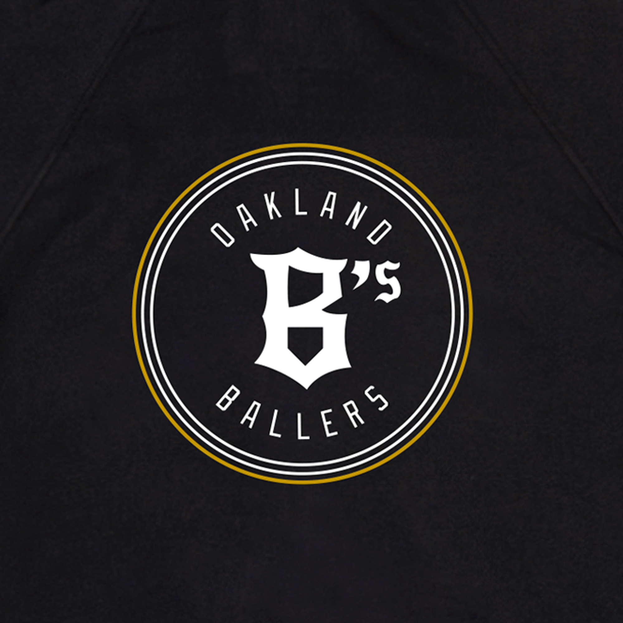 Showcasing a sporty, emblem-style design, the Oakland Ballers Logo Zip by Oakland Ballers features a black backdrop with a white circle highlighted by yellow accents. At its heart, bold white lettering curves around a large, stylized “B’s,” proudly representing the Oakland baseball team in the Pioneer League.