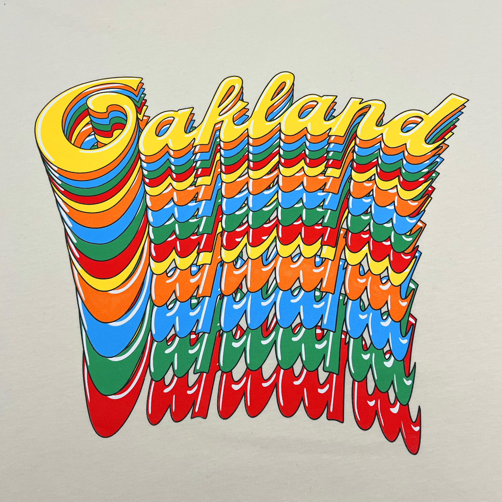 The Oakland Roots SC Funk Tee, by Oakland Roots SC, showcases the word "Oakland" in a retro, layered font with a shadow effect that creates a repeated, cascading visual. Each letter is adorned with vibrant colors like yellow, orange, red, blue, and green against a plain background—perfectly capturing the spirited vibe of the Oakland Roots Sports Club.