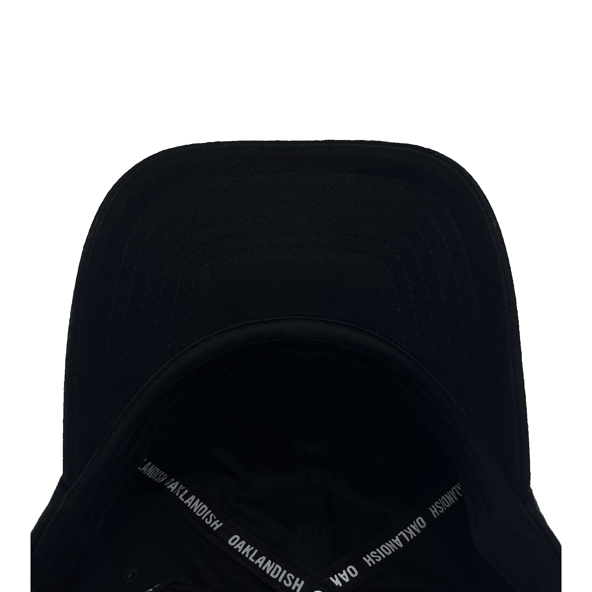 An Oakland Roots SC Logo Curved Visor Hat in black is displayed upside down, unveiling its interior. The inner rim is lined with the text “oaklandish.live” printed repeatedly in white. The visor's underside features noticeable stitch lines, and the exterior remains free of any logos or additional markings, capturing the essence of the Oakland Roots sports club.