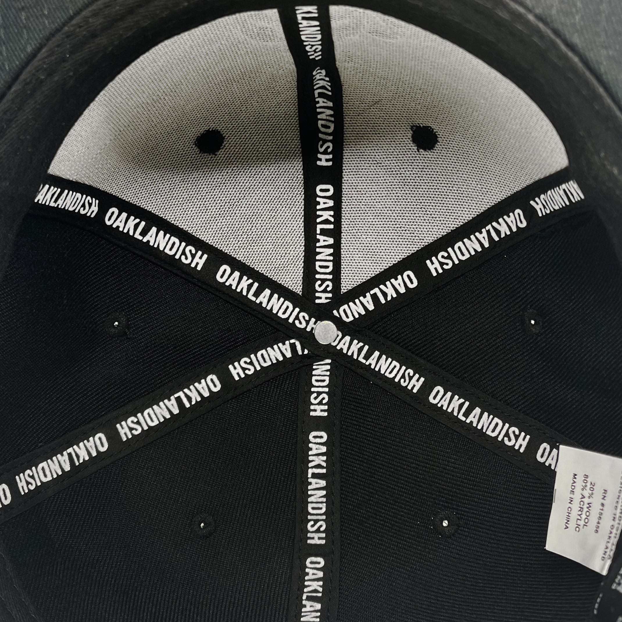 Detailed close up of Oaklandish  taping inside the crown of black cap.